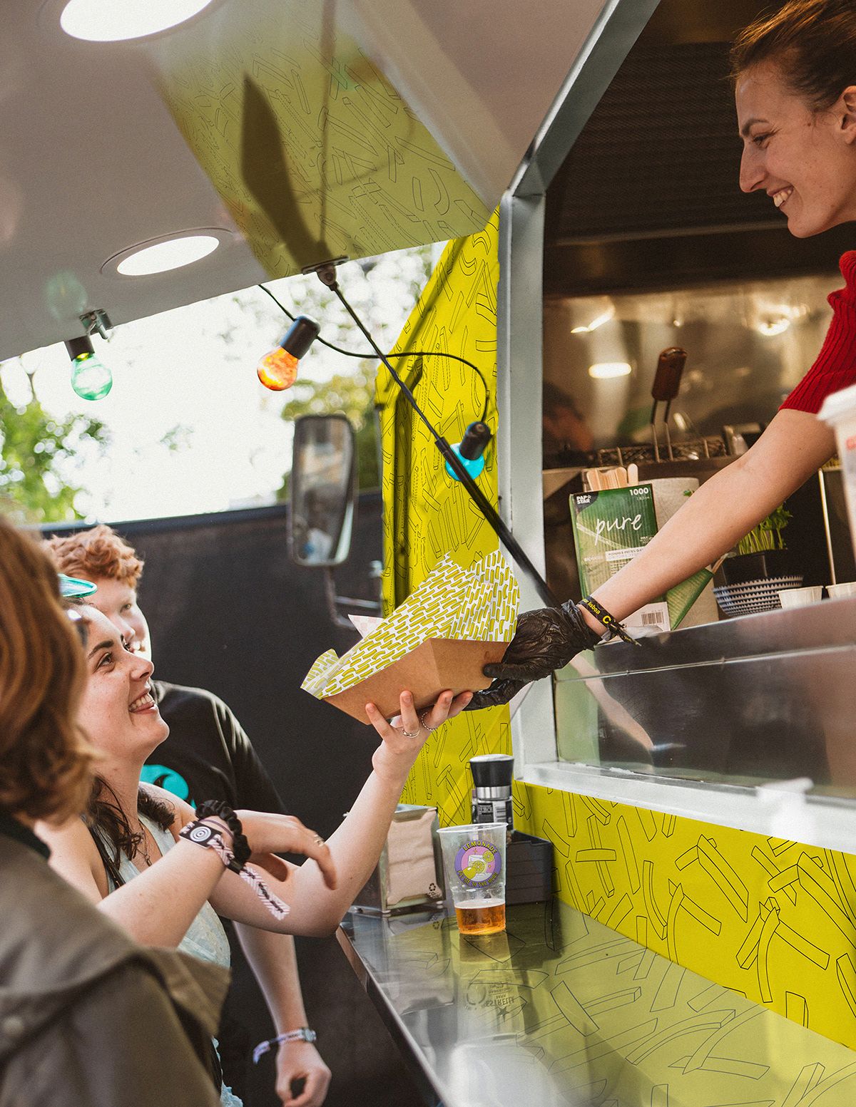 Vendor handing food to a happy customer at the truck window